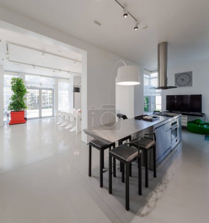 Photo for Modern white interior of spacious private house. Kitchen and dinner room. Table and chairs. - Royalty Free Image