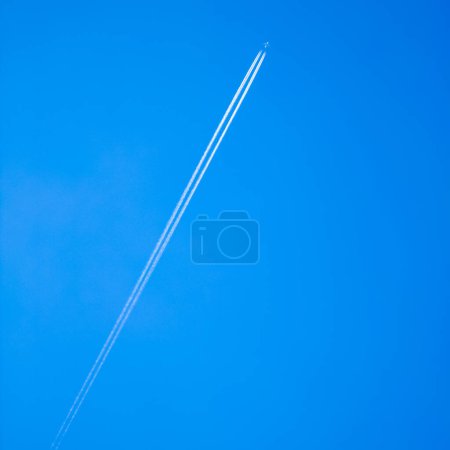 Photo for Large aircraft flying in sky. White lane. Blue sky. - Royalty Free Image