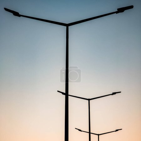 Photo for Street lights on the highway against the backdrop of the sunset sky - Royalty Free Image