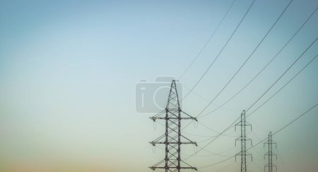 Photo for High voltage electricity power line towers against the sky - Royalty Free Image