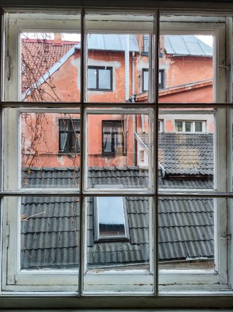Photo for Old window. View of black roof and red wall of old building. Europe. - Royalty Free Image
