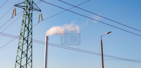 Foto de Chimenea de fábrica con humo. Tubo industrial. Torre de línea eléctrica - Imagen libre de derechos