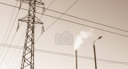 Foto de Chimenea de fábrica con humo. Tubo industrial. Torre de línea eléctrica - Imagen libre de derechos