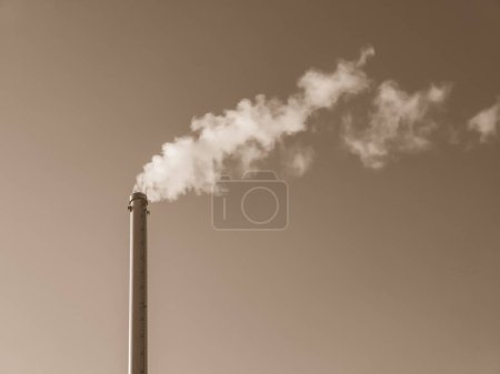 Téléchargez les photos : Cheminée d'usine avec fumée. Tuyau industriel. Ciel bleu au soleil - en image libre de droit