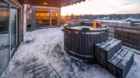 Photo for Open terrace with hot outdoor wooden bath tub at winter. Luxury private house. Modern cottage. - Royalty Free Image