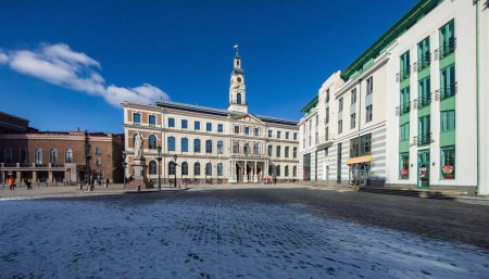 Foto de Plaza del Ayuntamiento de Riga. La torre del reloj. Arquitectura moderna de Letonia. Turismo en Europa. - Imagen libre de derechos