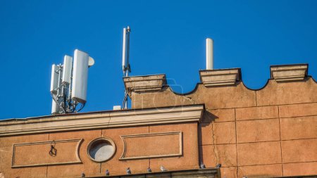 Foto de Antena de comunicación inalámbrica en la azotea del edificio antiguo. Arquitectura moderna. Cielo azul. - Imagen libre de derechos