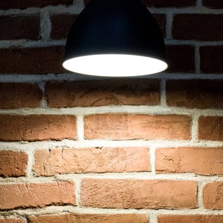 Téléchargez les photos : Gros plan d'une lampe près d'un mur de briques. Éclairage. - en image libre de droit
