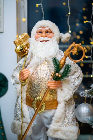 Foto de Hermosa muñeca grande de Santa Claus. Árbol de Navidad. Luces Bokeh. - Imagen libre de derechos