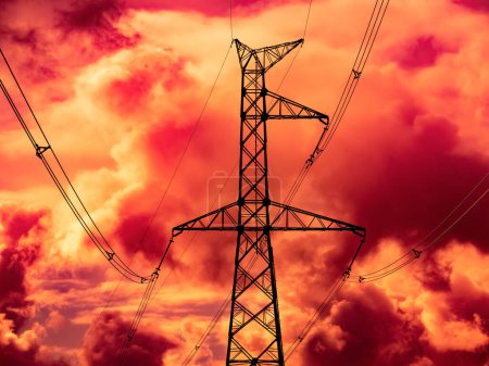 Téléchargez les photos : Tours de lignes électriques haute tension contre ciel apocalyptique nuageux rouge - en image libre de droit