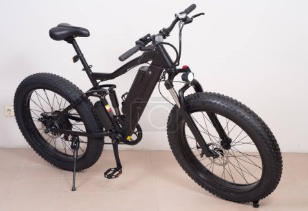 Foto de Moderna bicicleta negra con ruedas gruesas y motor eléctrico. - Imagen libre de derechos