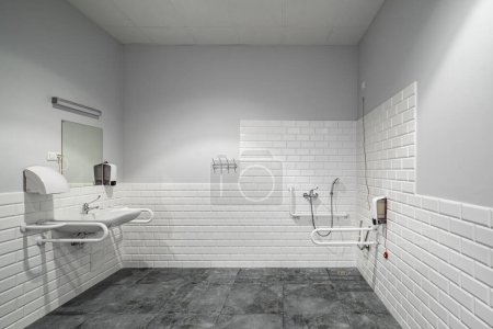 Photo for The interior of bathroom with facilities for the disabled. White bricks. Grey tile. - Royalty Free Image