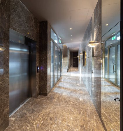 Foto de Moderno interior de hall de entrada en complejo residencial de lujo. Suelo de mármol y paredes. Ascensor. - Imagen libre de derechos