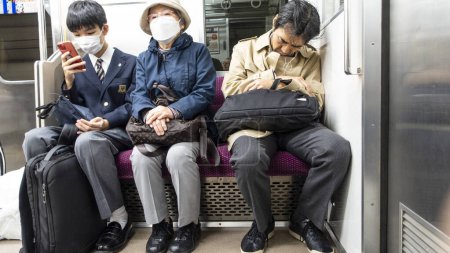 Photo for Japan, April 2024 : three generations people sitting in JR subway train in Tokyo, Japan. Railways are the most important means of passenger transportation in Japan. - Royalty Free Image
