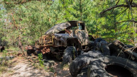 Foto de Destruido coche abandonado en la ciudad fantasma de Pripyat después de la explosión cuarto reactor central nuclear de Chernobyl. Zona de exclusión. Ucrania. Radiación, catástrofe - Imagen libre de derechos