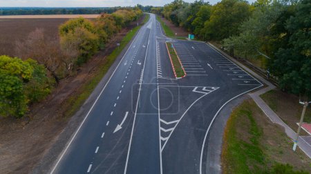 Téléchargez les photos : Drone vue aérienne nouvelle route asphaltée en automne par temps nuageux, marquage routier - en image libre de droit