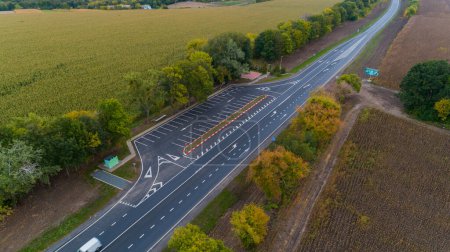 Téléchargez les photos : Drone vue aérienne nouvelle route asphaltée en automne par temps nuageux, marquage routier - en image libre de droit