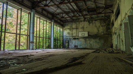 Foto de Dentro del complejo deportivo destruido edificio abandonado Casa Cultura Energetik en la ciudad fantasma Pripyat después de la explosión cuarto reactor central nuclear de Chernobyl. Zona de exclusión. Radiación. Ucrania - Imagen libre de derechos