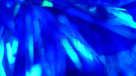Photo for Neon blue light highlights and bokeh on a dark night background. Reflections of a crystal. Christmas holidays. - Royalty Free Image