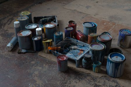 Photo for Old Paint Cans. Cans of colored paint. Oil-based enamel, lacquer, shellac and varnish leftovers. Household Hazardous Waste. High quality photo - Royalty Free Image