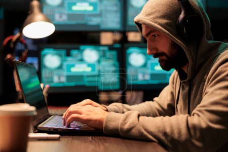 Programmierdieb hackt Sicherheitssystem auf Computer und benutzt Entwickler-Malware, um große Datenmengen vom Server zu stehlen. Nachts mit mehreren Monitoren arbeiten, um wichtige Informationen zu hacken, Cyberkriminalität.