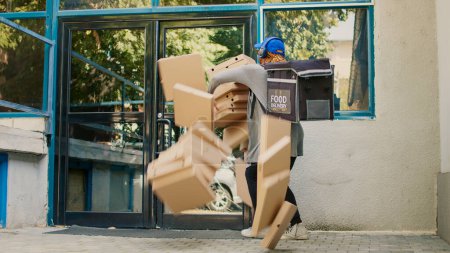 Photo for Reckless fastfood employee dropping pizza boxes, afraid femlae carrier running from customer outdoors. Clumsy courier delivering pizzeria food order, bad delivery service. Tripod shot. - Royalty Free Image