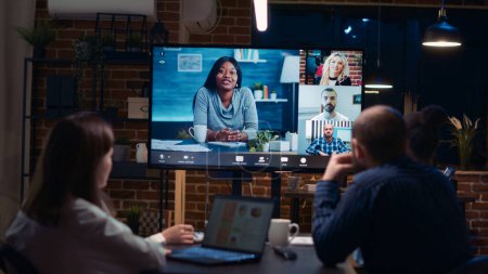 Photo for Employees planning strategy with remote team in teleconference app, coworkers brainstorming videoconference. Diverse office workers listening to presentation in online business meeting. Handheld shot. - Royalty Free Image