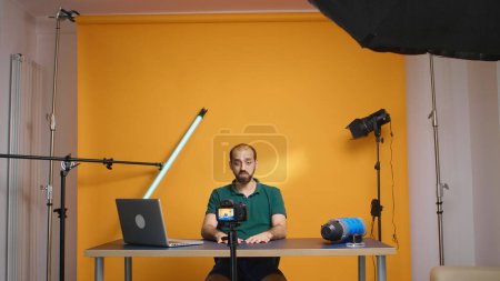 Photo for Famous vlogger recording video for subscribers looking at the camera in studio. Social media podcast and review, blogging vlogging, digital internet web era, influencer recording for online - Royalty Free Image
