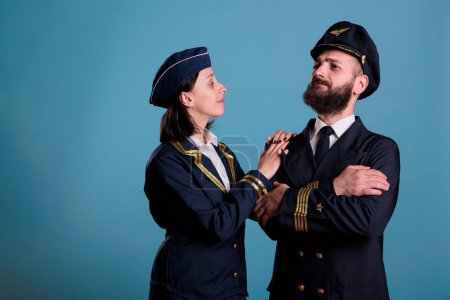 Photo for Confident airplane pilot and flight attendant couple in professional uniform portrait, studio medium shot. Serious airplane crew, plane captain and air hostess standing, airline team - Royalty Free Image