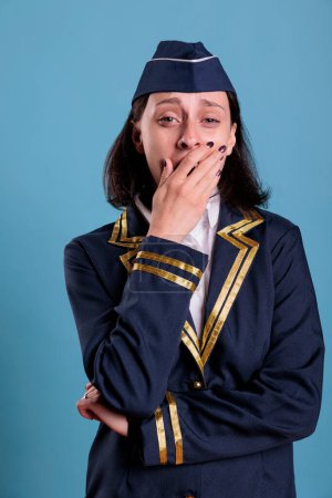 Photo for Stewardess covering mouth with hands, showing speak no evil gesture, looking at camera. Airplane Flight attendant with covered lips front view, censorship, keeping silence concept - Royalty Free Image