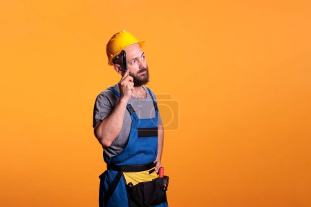 Photo for Pensive construction worker thinking about renovating work, brainstorming ideas and holding pair of pliers. Young building crafts man using tools and working on refurbishment job. - Royalty Free Image