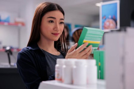 Photo for Cheerful woman client holding drugs package looking at pharmaceutical leaflet during medicine shopping in pharmacy, Client buying supplements, vitamin for a healthy immune system. Medicine support - Royalty Free Image