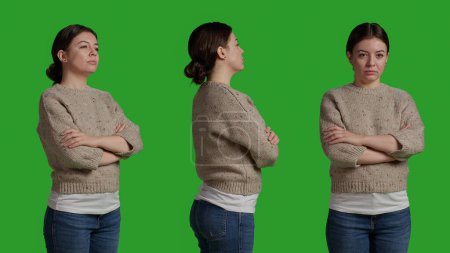 Téléchargez les photos : Close up of smiling person with sweater acting lovely over isolated greenscreen backdrop in studio. Modern person being positive and happy, confident model on camera over green screen. - en image libre de droit
