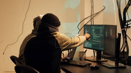 Téléchargez les photos : Skilled web thief hacking network with digital espionage concept, stealing important government information. Male hacker working with trojan virus to hack firewall, doing cyberattack. - en image libre de droit