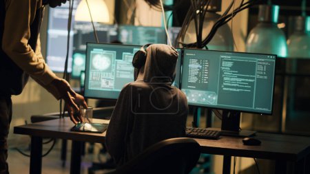Foto de Female thief using her knowledge of network systems to access data and steal passwords. Criminal breaking security firewall for cyber espionage, hacktivism cryptojacking. Handheld shot. - Imagen libre de derechos