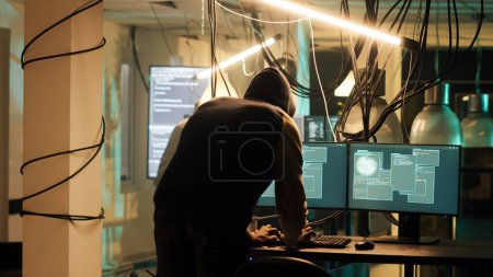 Successful hacker planning data breach to take sensitive information without authorization. Male thief doing espionage and breaking into computer system with dark web malware.