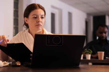 Photo for Office manager checking company report, comparing data on computer website. Corporate worker analyzing research result, employee working on laptop at workplace desk in coworking space - Royalty Free Image