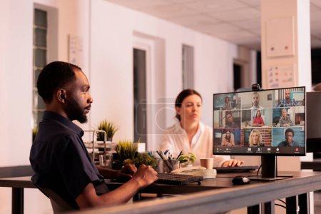 Téléchargez les photos : Employee talking with colleagues on online meeting, having conversation on corporate videocall. African american man discussing startup plan on teleconference, telecommuting - en image libre de droit