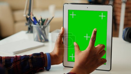 Foto de Emprendedora verticalmente sosteniendo una pantalla verde aislada en una tableta digital, mirando la pantalla de croma en blanco con fondo de maqueta. Uso de espacio de copia en el dispositivo portátil. De cerca.. - Imagen libre de derechos