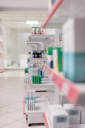 Foto de Empty drugstore equipped with shelves full with health care products and supplements ready for clients. Pharmacy store with nobody in it filled with vitamins, drugs packages and pills bottles - Imagen libre de derechos