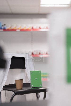 Téléchargez les photos : Greenscreen chroma key mock up pills packages standing vertically on chair in pharmacy, empty drugstore filled with pharmaceutical products and supplements. Health care service support and concept - en image libre de droit