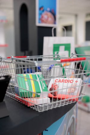 Foto de Pharmacy counter desk was cluttered with store shopping basket filled with boxes and packages of various medical supplies, ready for clients to come and buy. Pharmaceutical products and vitamins - Imagen libre de derechos