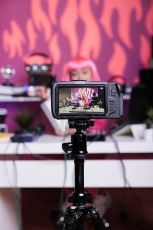 Téléchargez les photos : Content creator filming white box review in recording studio talking with subscribers using professional vlogging camera. Asian influencer talking with subscribers during live streaming - en image libre de droit