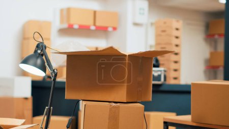 Photo for Empty storage room with cardboard boxes on shelves and racks, warehouse used to ship merchandise orders to customers. Storehouse space filled with products, distribution and budgeting work. - Royalty Free Image