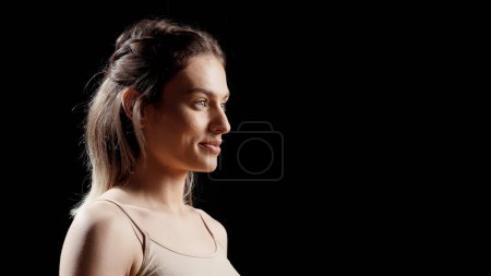 Foto de Young beauty model feeling confident about bare skin, posing on camera without makeup. Happy woman smiling and creating skincare ad campaign, promoting self acceptance in studio. - Imagen libre de derechos