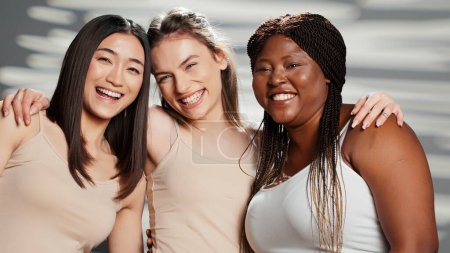 Photo for Curvy skinny interracial models filming body positivity ad, expressing self acceptance and body confidence in studio. Confident women showing femininity for skincare campaign, self love concept. - Royalty Free Image