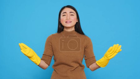 Photo for Happy asian maid being happy about finishing house cleaning while enjoying appreciation from her customers. Homekepper doing wonderful job, making sure every inch of the house was spotless. - Royalty Free Image