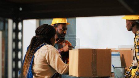 Photo for Group of employees working on logistics and packing supplies, checking stock in storage room for inventory. People using carton boxes with products from racks, retail distribution. - Royalty Free Image