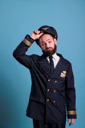 Photo for Airplane capitan taking hat off, looking at camera with confused facial expression. Puzzled aviation academy plane pilot front view, navy aviator holding cap with airforce badge wings - Royalty Free Image