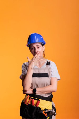 Photo for Tired exhausted woman constructor yawning and feeling sleepy, falling asleep standing in studio. Overworked construction expert being fatigued and feeling burnout after building work. - Royalty Free Image